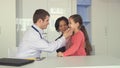 Doctor checks up little girl at the office