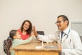 doctor cheering up making high five with a little child girl at doctor\'s office. single mother taking her kid