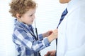 Doctor and child patient. Little boy play with stethoscope while physician communicate with him. hildren`s therapy and Royalty Free Stock Photo