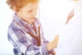 Doctor and child patient. Little boy play with stethoscope while physician communicate with him. hildren`s therapy and Royalty Free Stock Photo