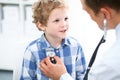 Doctor and child patient. Physician examines little boy by stethoscope. Medicine and children`s therapy concept