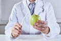 Doctor cleaning green apple with toothbrush