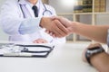 doctor at the clinic giving an handshake to his patient for encouragement and empathy, healthcare and assistance concept. Royalty Free Stock Photo