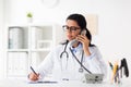 Doctor with clipboard calling on phone at hospital Royalty Free Stock Photo