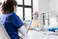 doctor with clipboard and senior woman at hospital Royalty Free Stock Photo