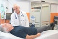 Doctor with clothed patient on hospital bed