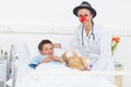 Doctor in clown costume with boy in hospital Royalty Free Stock Photo