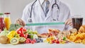 Doctor in coat holding ruler over table with food