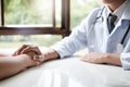 Doctor comforting patient at consulting room Royalty Free Stock Photo