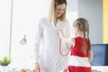 Doctor communicates with little girl who is holding stethoscope Royalty Free Stock Photo