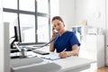 Doctor with computer calling on phone at hospital Royalty Free Stock Photo