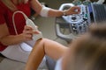 Doctor conducting ultrasound examination of elbow joint of patient hand in clinic closeup