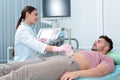 Doctor conducting ultrasound examination of patient`s abdomen