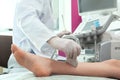 Doctor conducting ultrasound examination of patient`s leg in clinic Royalty Free Stock Photo