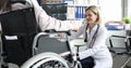 Doctor conducts study of the patellar reflex on knee of patient in wheelchair