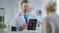 Doctor Consultation Office: Female Patient Listens to Experienced Cardiologist Uses Digital Tablet Royalty Free Stock Photo