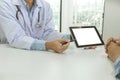 Doctor consulting patient and recommend treatment methods and how to rehabilitate the body, presenting results on tablet computer Royalty Free Stock Photo