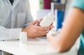Doctor consulting patient about right medication. Physician holding medicine and pills in hand. Royalty Free Stock Photo