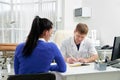 Doctor consulting young woman in his office