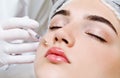 The doctor cosmetologist beautician makes the rejuvenating facial botox injections procedure for tightening and smoothing wrinkles