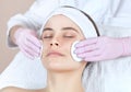 The doctor cosmetologist cleanses with a tonic the face skin of a beautiful, young woman in a beauty salon Royalty Free Stock Photo