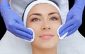 The doctor cosmetologist cleanses with a tonic the face skin of a beautiful, young woman Royalty Free Stock Photo