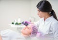 Hands of cosmetologist making ultrasound facial cleaning with special machine Royalty Free Stock Photo