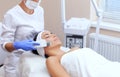 The doctor-cosmetologist makes the apparatus a procedure of ultrasound cleaning of the facial skin of a beautiful, young woman