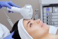 The doctor-cosmetologist makes the Cryotherapy procedure of the facial skin of a beautiful, young woman in a beauty salon. Royalty Free Stock Photo