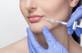 The doctor cosmetologist makes Lip augmentation procedure of a beautiful woman in a beauty salon