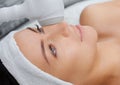 The doctor-cosmetologist makes the procedure Cryotherapy of the facial skin of a beautiful, young woman in a beauty salon. Royalty Free Stock Photo