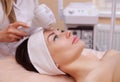 The doctor-cosmetologist makes the procedure Cryotherapy of the facial skin of a beautiful, young woman in a beauty salon. Royalty Free Stock Photo