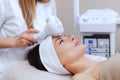 The doctor-cosmetologist makes the procedure Cryotherapy of the facial skin of a beautiful, young woman in a beauty salon Royalty Free Stock Photo