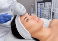 The doctor-cosmetologist makes the procedure Cryotherapy of the facial skin of a beautiful, young woman Royalty Free Stock Photo