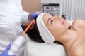 The doctor-cosmetologist makes the procedure Microcurrent therapy On the hair of a beautiful, young woman Royalty Free Stock Photo