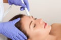 The doctor-cosmetologist makes the procedure treatment of Couperose of the facial skin of a beautiful, young woman in a beauty Royalty Free Stock Photo