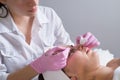 The doctor-cosmetologist makes the procedure treatment of Couperose of the facial skin of a beautiful, young woman in a beauty Royalty Free Stock Photo