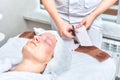 Doctor cosmetologist prepares collagen face mask for female patient