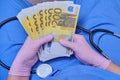 The doctor counts the bills in euros, close-up. The concept of paying doctors during the coronavirus and other diseases pandemic