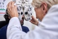 Doctor with customer in vision test or eye exam for eyesight by doctor, optometrist or ophthalmologist. Senior optician Royalty Free Stock Photo