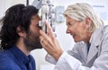 Doctor with a customer in vision test or eye exam for eyesight by a senior optometrist or ophthalmologist. Happy Royalty Free Stock Photo