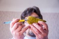 Doctor on defocused background holds in his hand anatomic model of pancreas gland, pointing with pen in hand on pancreas in foregr