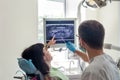 Doctor dentist pointing on patient`s X-ray on monitor Royalty Free Stock Photo