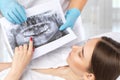 Doctor dentist shows the patient an x-ray of the upper and lower jaw of a young beautiful woman in a dental clinic. Dental concept Royalty Free Stock Photo