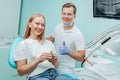Doctor dentist and young woman patient smiling in dental clinic with medical equipment, x-ray dental, tools. Smile healthy teeth Royalty Free Stock Photo