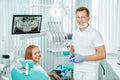 Doctor dentist and young woman patient smiling in dental clinic with medical equipment, x-ray dental, tools. Smile healthy teeth Royalty Free Stock Photo