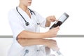 Doctor at desk touch tablet in medical office, remot control