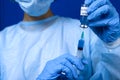 doctor dials a Coronavirus vaccine from a glass ampoule into a syringe