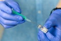 doctor dials the vaccine into a syringe. a nurse with a vaccine and a syringe in her hands