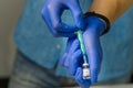 doctor dials the vaccine into a syringe. a nurse with a vaccine and a syringe in her hands